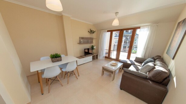 A modern apartment with a dining area, sofa, and a TV. - MAR DE VICEDO - PENTHOUSE 2 BEDROOMS WITH TERRACE (O Vicedo)