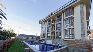 A multi-story building with a swimming pool, stone facade, and balconies. - MAR DE VICEDO - PENTHOUSE 2 BEDROOMS WITH TERRACE (O Vicedo)