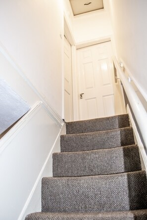Stairs lead to a door at the top, offering access to a space.