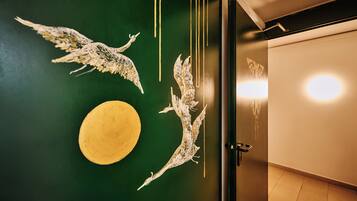 A room with a green wall, a yellow circular object, and two white bird sculptures.