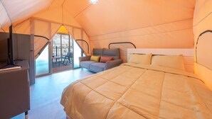 A tent-style bedroom with a bed, a sofa, and a desk with a laptop. - Gapyeong Haemogglamping (Gapyeong)