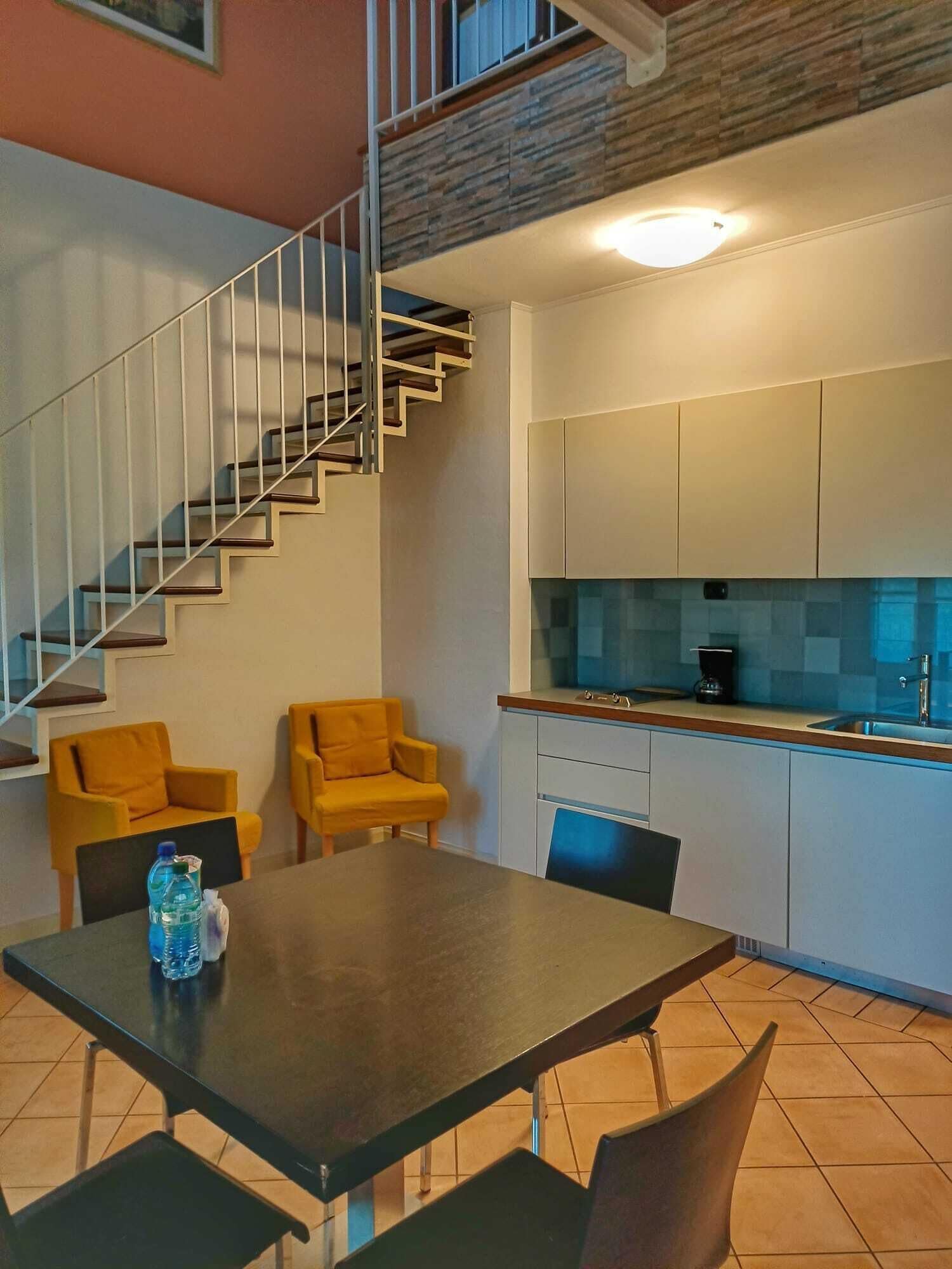 A modern kitchen with white cabinets, a built-in oven, and a coffee maker on the counter.