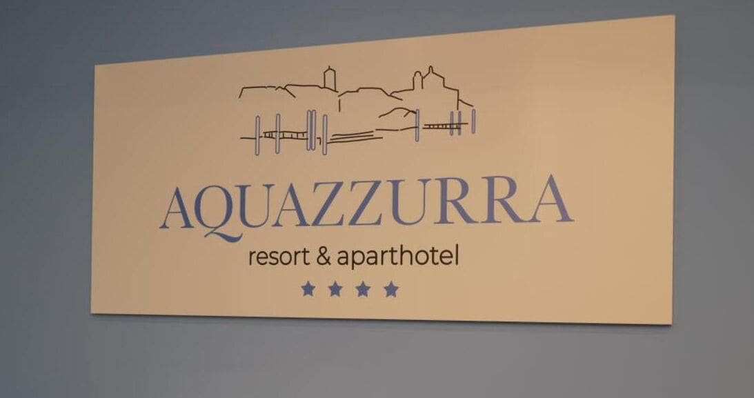 A sign for Aquazzurra resort & apartment hotel with a simple design and three stars rating.
