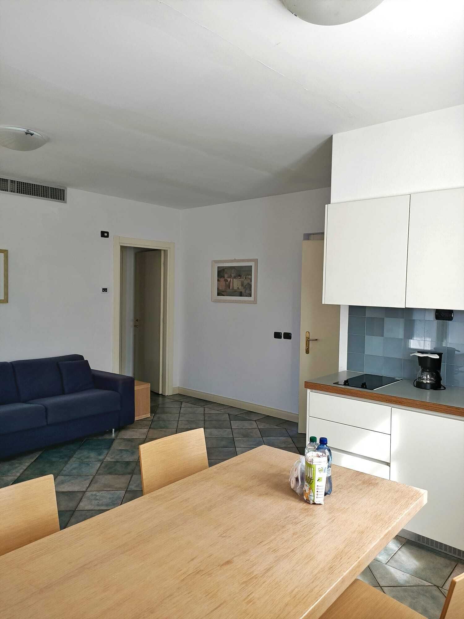 Un appartement moderne comprenant un coin repas, un canapé, une cuisine et une porte donnant sur une autre pièce.