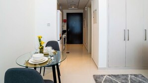 Una cocina moderna con armarios blancos y una puerta oscura.