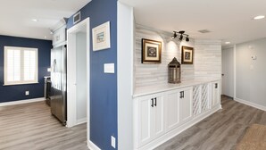 A modern kitchen with white cabinets, a stainless steel refrigerator, and a wooden backsplash. - Inlet View 2 BR Condo! Marlin Quay 206 (Garden City)