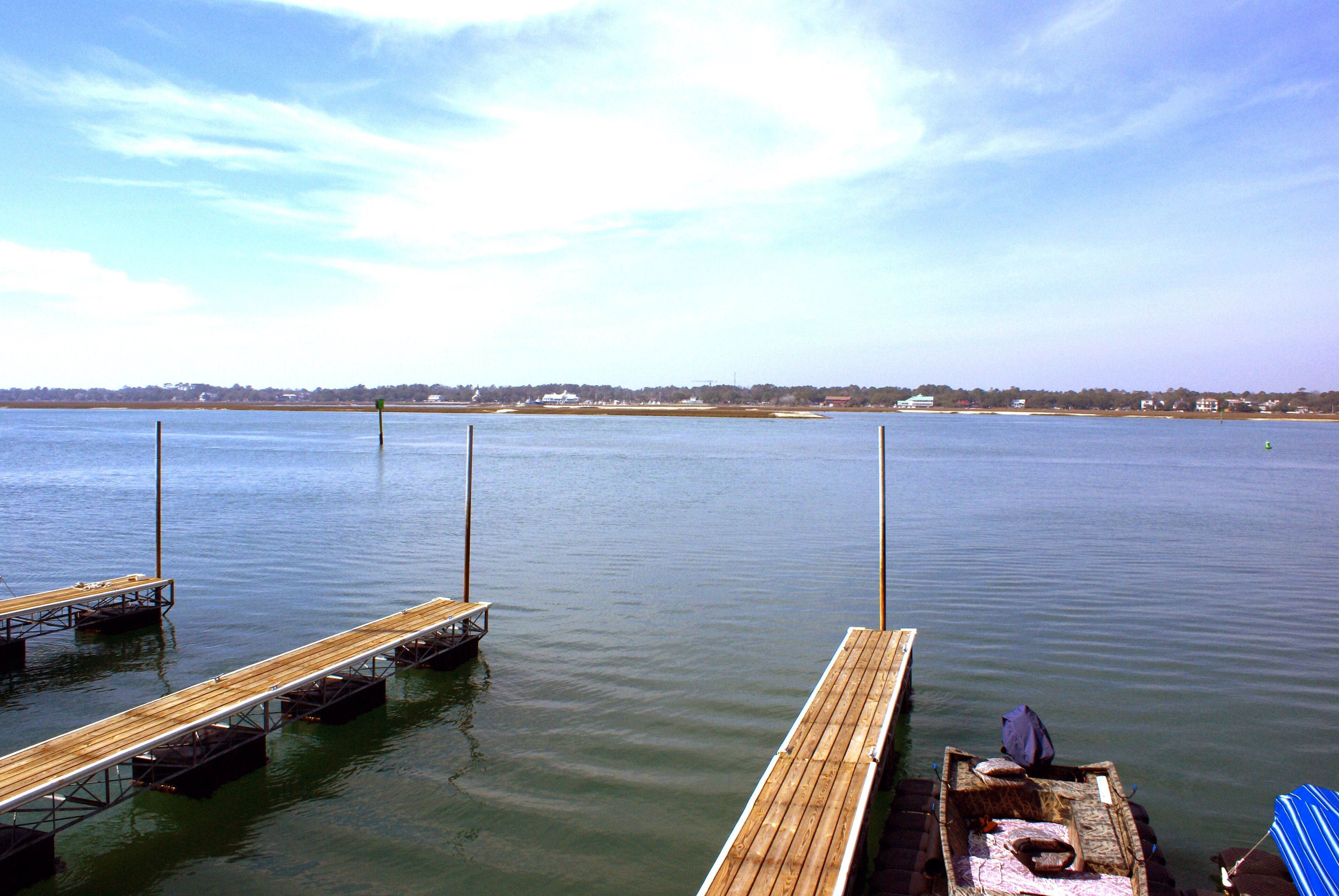 A calm waterfront with wooden docks and a small boat.