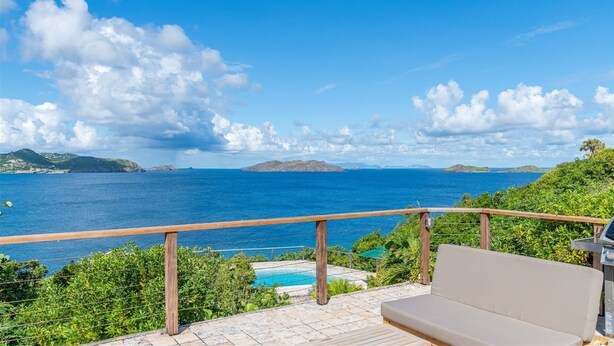 Ein Balkon mit Blick auf das Meer und einen Pool.