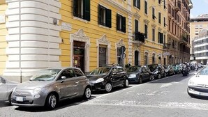 A street lined with parked cars and yellow buildings with classical architecture. - Palestrina   Prati area, Rome (ROMA)