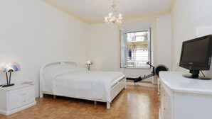 A bedroom with a bed, a desk with a computer, a chair, a lamp, and a window. - Palestrina   Prati area, Rome (ROMA)