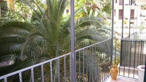 A balcony with metal railings, surrounded by lush green palm trees. - Palestrina   Prati area, Rome (ROMA)