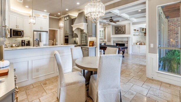 A spacious kitchen with a central island, white cabinetry, and a chandelier. - Luxurious Home-Resort Style Pool & Game Room (Plano)