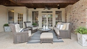An outdoor patio with wicker furniture, a round table, and a ceiling fan. - Luxurious Home-Resort Style Pool & Game Room (Plano)