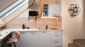 Une cuisine moderne avec un plafond en bois, un four à micro-ondes encastré, un évier et une étagère hexagonale.