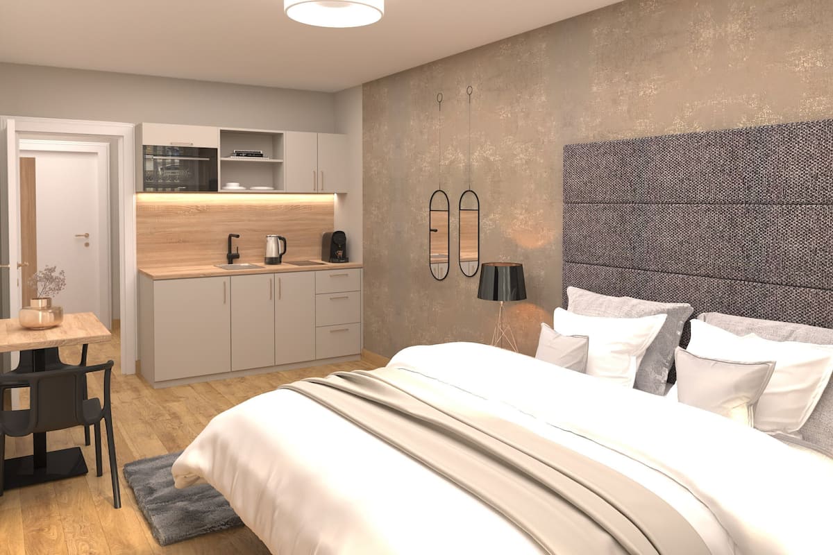 A modern bedroom with a large bed, a small kitchenette, and a dining area.