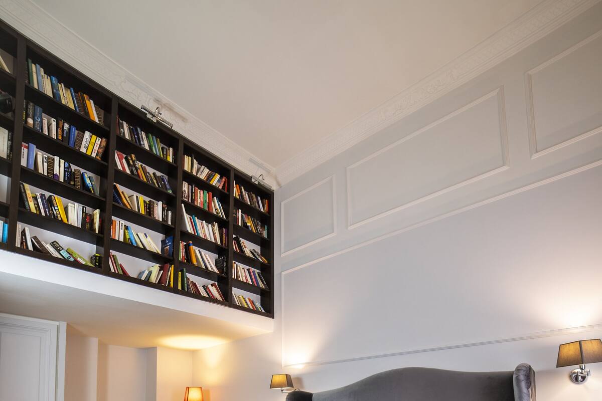 Un dormitorio con una cama grande, una estantería, un escritorio y una silla.