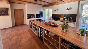 Une cuisine moderne avec des meubles en bois, un grand îlot central et des appareils électroménagers intégrés.