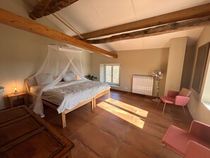 A bedroom with a bed under a canopy, a bedside table with a lamp, a radiator, a chair, and a window with daylight. - Il Gattopardo, ART HOUSE private villa 19 quests, near Mediterranean coast. (Liguria)