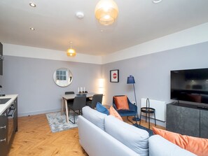 Un salon moderne avec un canapé, une table à manger et un téléviseur.