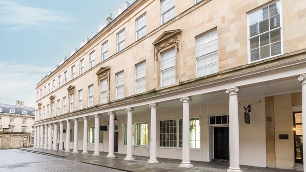 Un edificio storico con una galleria coperta e colonne.