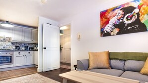 Un salon moderne avec un canapé, une table basse et une cuisine en arrière-plan.
