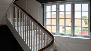 Un escalier avec des rampes blanches et des marches en bois menant à un palier.