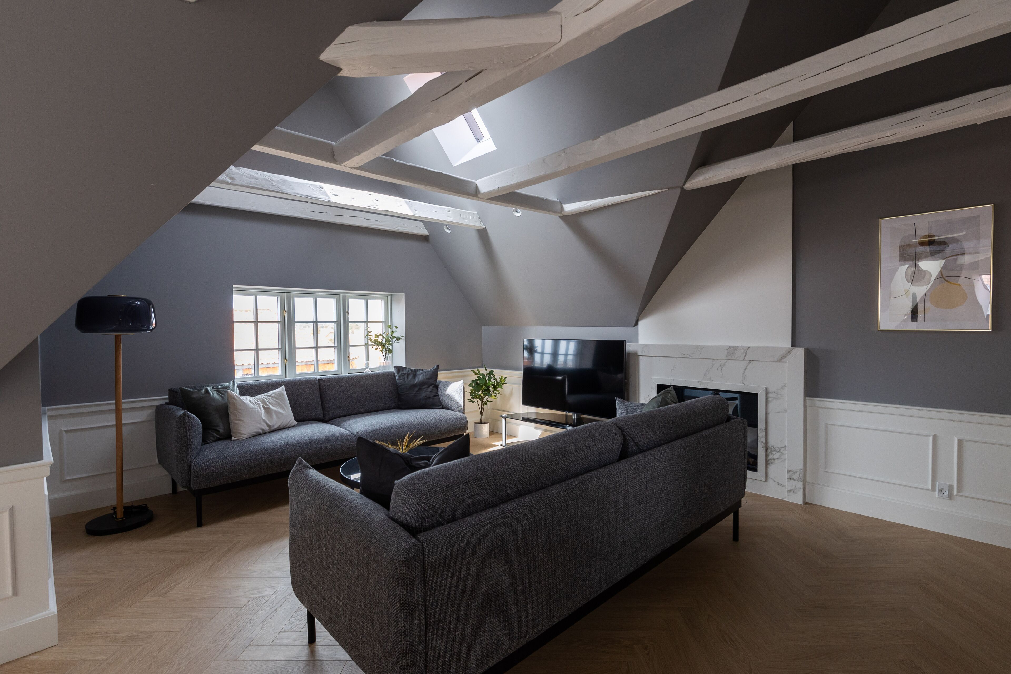 A modern living room with a sectional sofa, a flat-screen TV, and a fireplace.