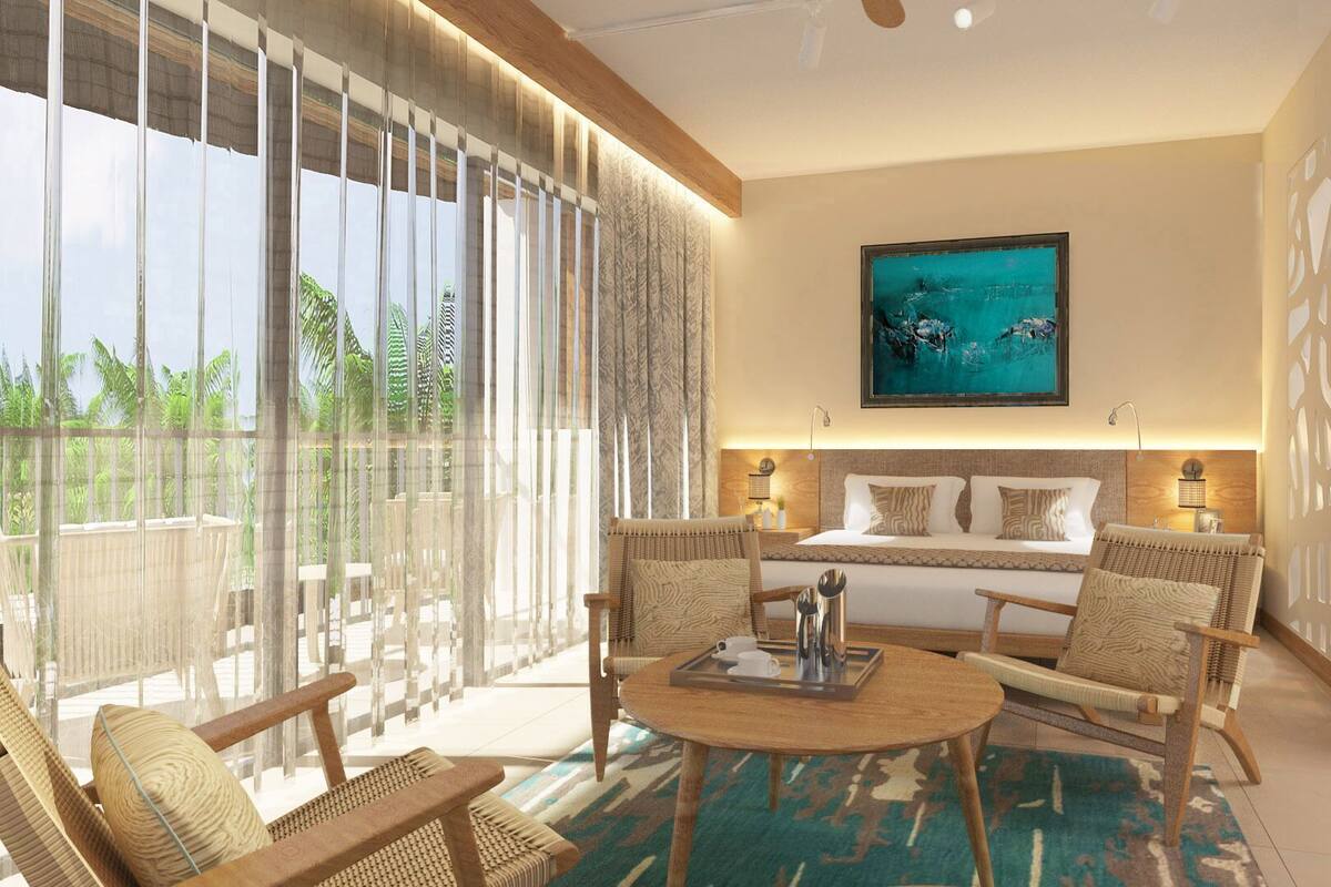 Une chambre d’hôtel moderne avec un balcon, un lit avec deux oreillers, une table de chevet et un tableau au mur.