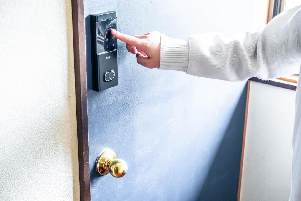 Una persona usando un sistema de teclado para abrir una puerta.