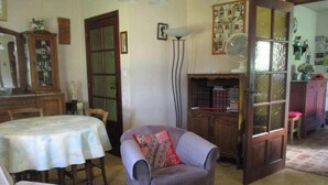 Ein Zimmer mit Esstisch, Stuhl, Bücherregal und Schrank.