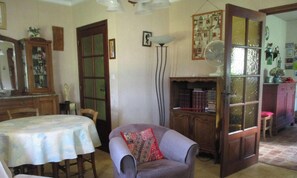 Une piĂšce comprenant une table Ă manger, une chaise, une bibliothĂšque et un meuble.
