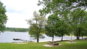 Ein Park am Seeufer mit Picknicktischen und einer Anlegestelle.