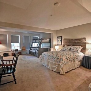 A bedroom with a bunk bed, a desk, and a chair.