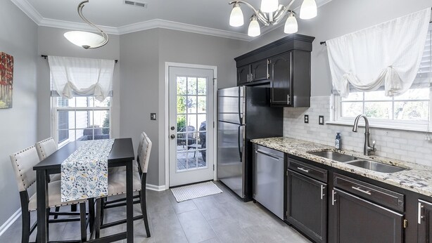 A modern kitchen with dark cabinetry, a stainless steel refrigerator, and a granite countertop. - Entire Home in Hamburg! (Lexington)