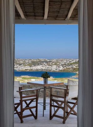 Enjoy a serene coastal view from this balcony with a table and two chairs.