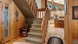 Ein Holzinnenraum mit einer Treppe, die zu einer Küchenzeile führt.