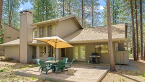 Ein Haus mit Terrasse, Sitzgelegenheiten im Freien und Grillplatz.