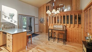 Eine geräumige Küche mit Holzelementen, einer zentralen Kochinsel und einem Schild mit der Aufschrift 'HOME'.