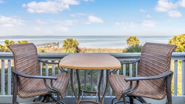 A balcony with wicker furniture and a view of the ocean. - Beach Racquet A221 by Tybee Vacation Rentals (Tybee Island)