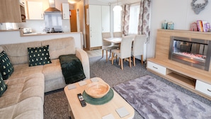 Un espacio habitable compacto con sofá, mesa de comedor y chimenea.