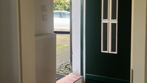 A room with a white door, a green wall, and a window. - Casa del mar - casa 1 (Cuxhaven)