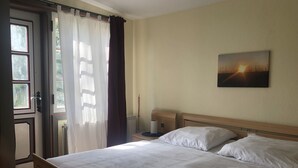A hotel room with a bed, a nightstand, a lamp, and a painting on the wall. - Casa del mar - casa 1 (Cuxhaven)