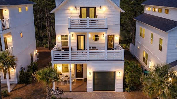 A two-story house with a balcony, a garage, and a driveway. - The Way Of Water 3 Bedroom Home by RedAwning (Panama City Beach)