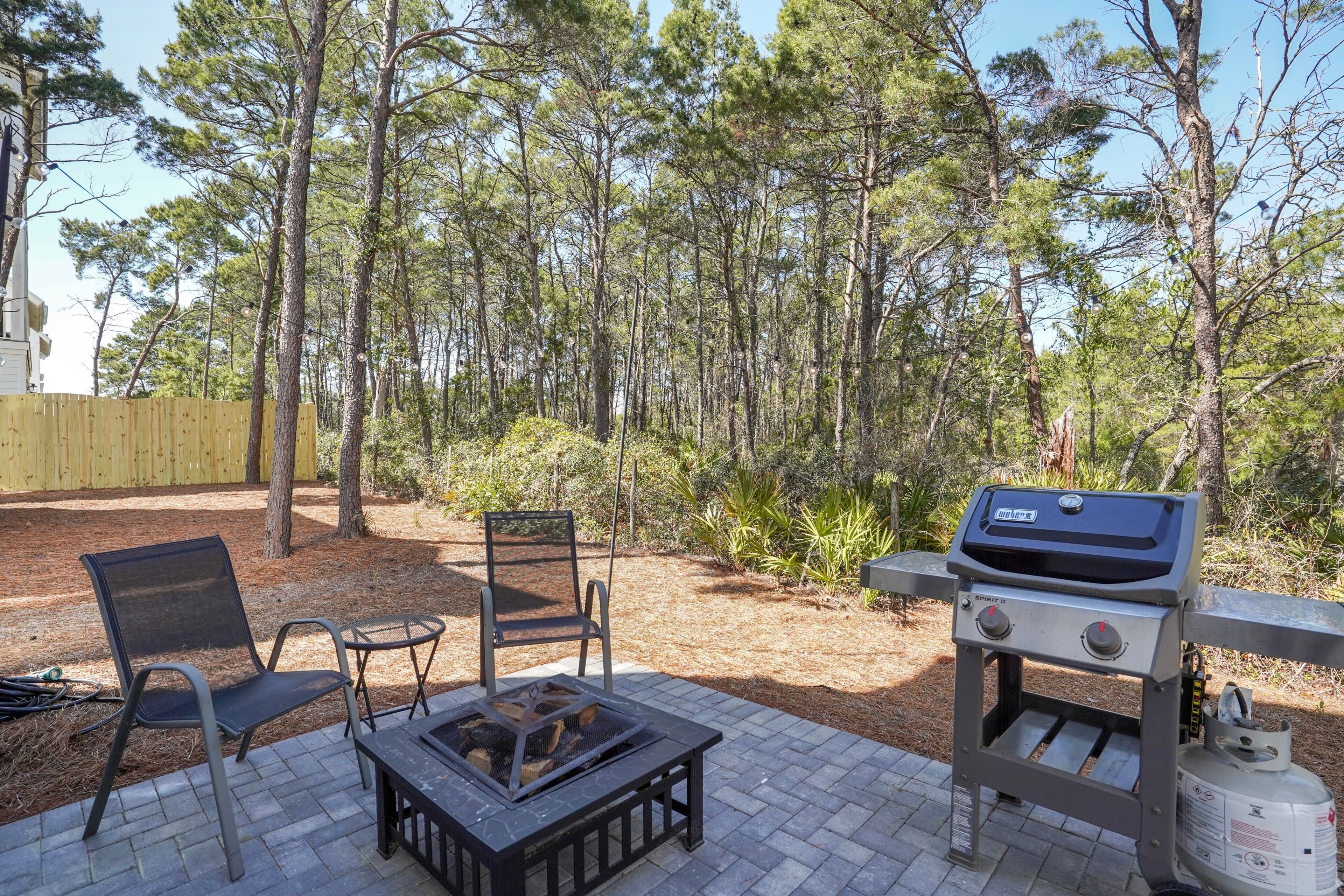 Eine Terrasse mit Grill, zwei Stühlen und einem Feuerkorb.