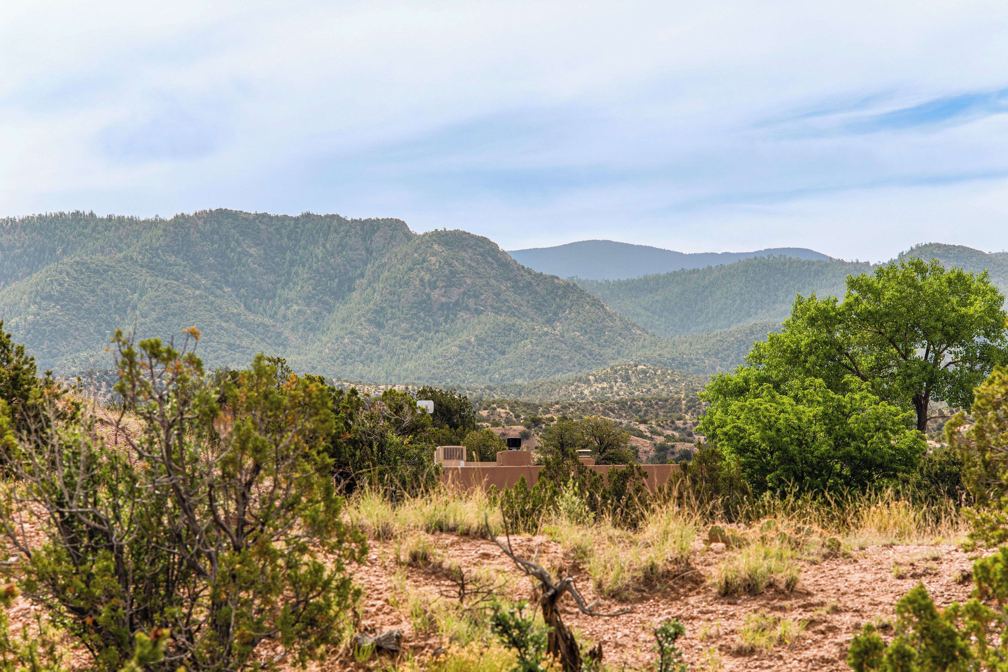 Paisagem montanhosa com vegetação escassa e céu limpo.
