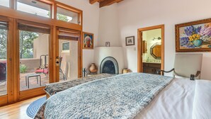 Um quarto com uma cama grande, lareira e vista para o exterior.