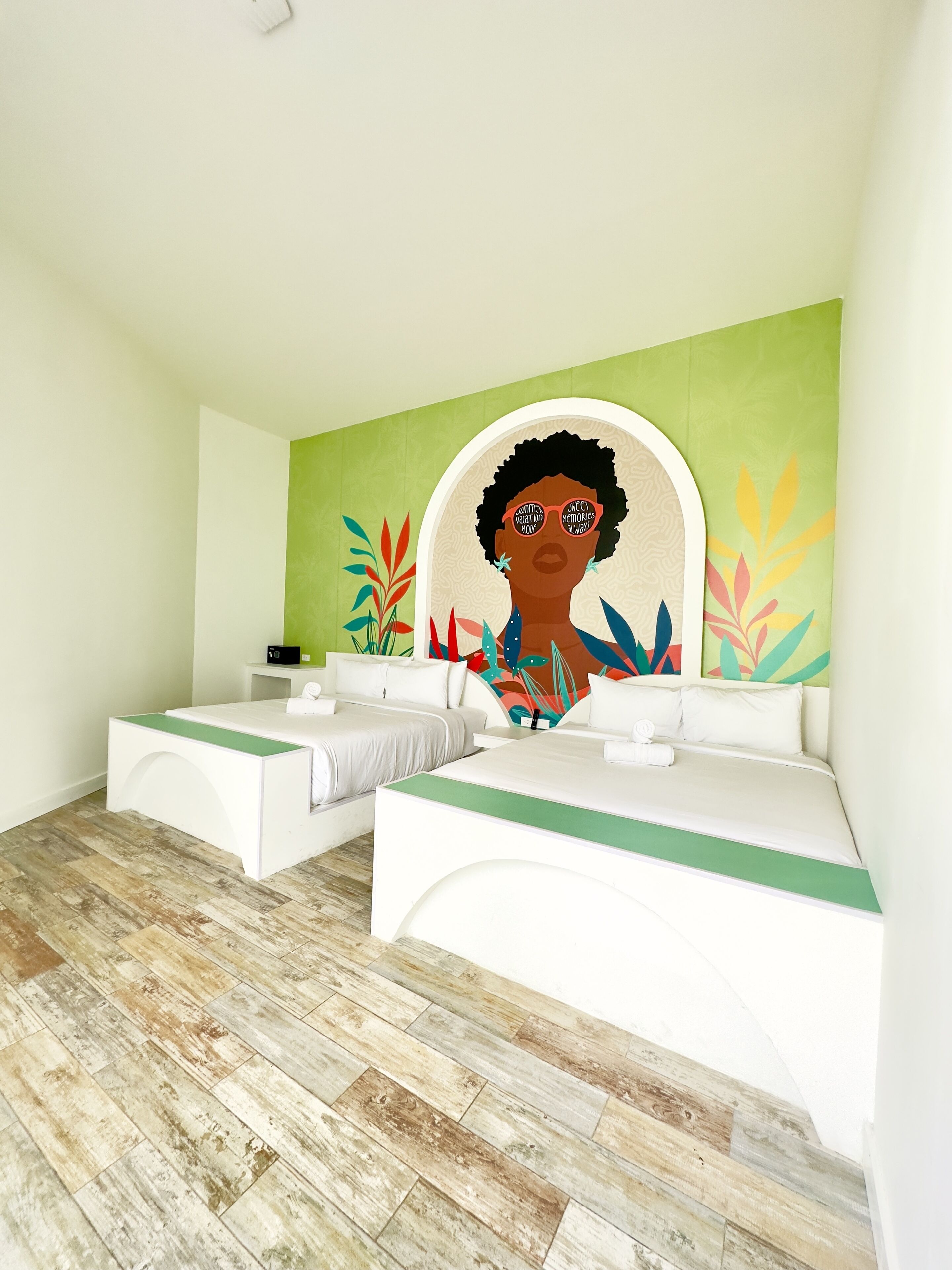 A modern bathroom with a large mirror, two sinks, and a green accent wall.