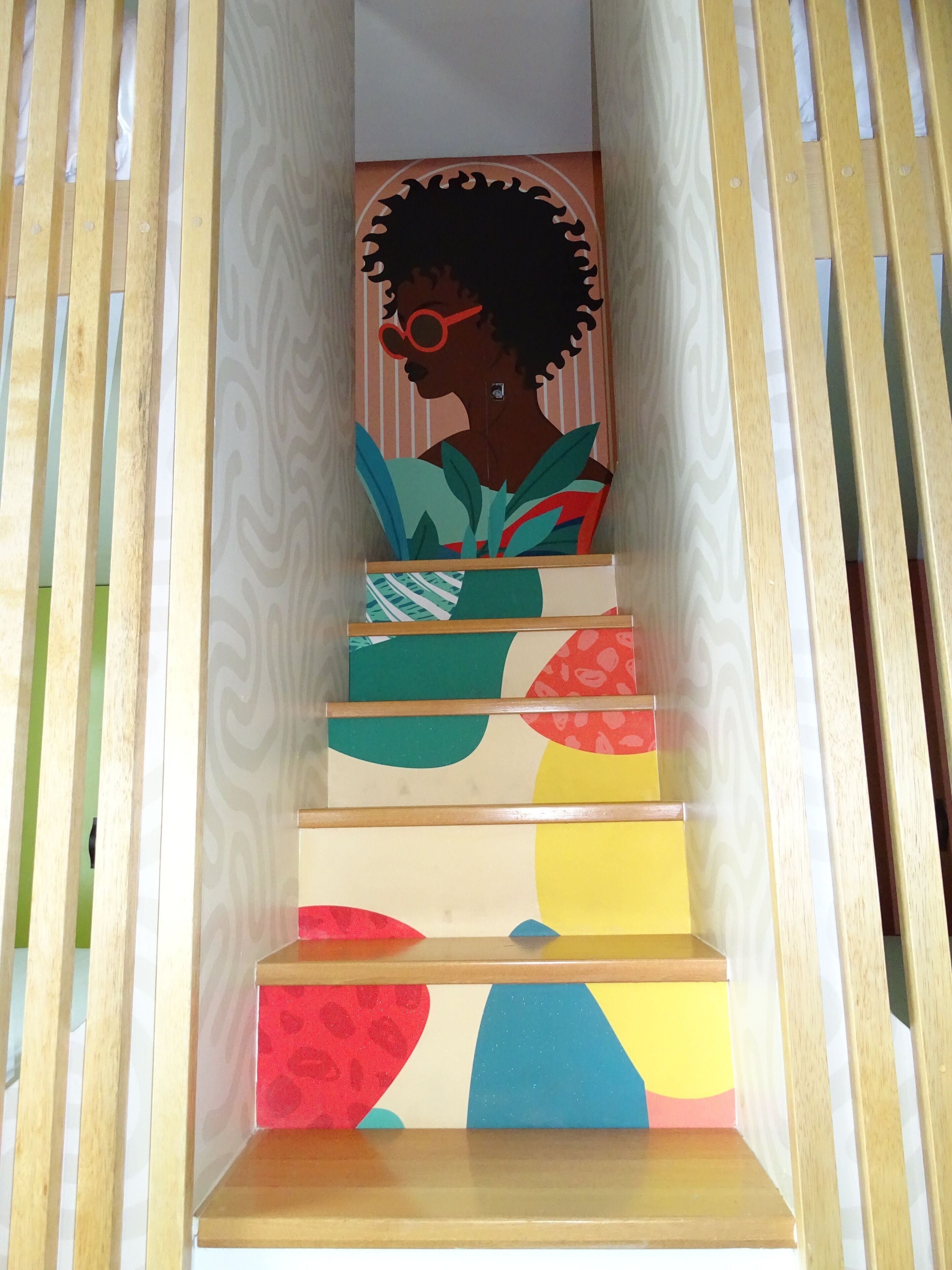 A staircase with colorful steps and a wooden railing.