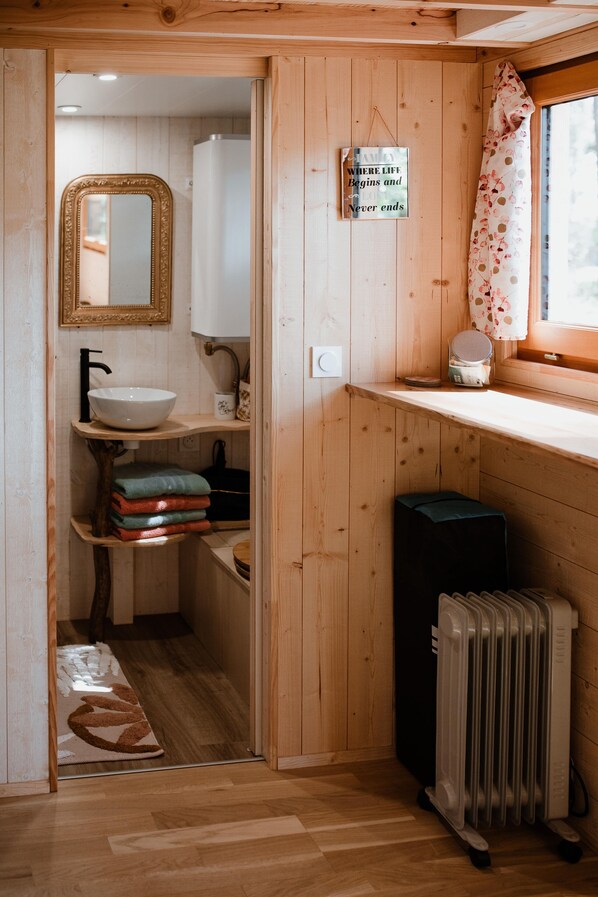 A wooden interior with a sink, mirror, and radiator. - Tiny Stay Ecolodge (Baugé-en-Anjou)