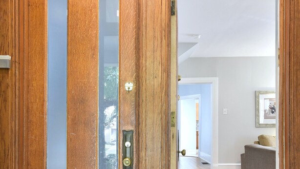Une porte en bois avec un panneau de verre et une poignée de porte.